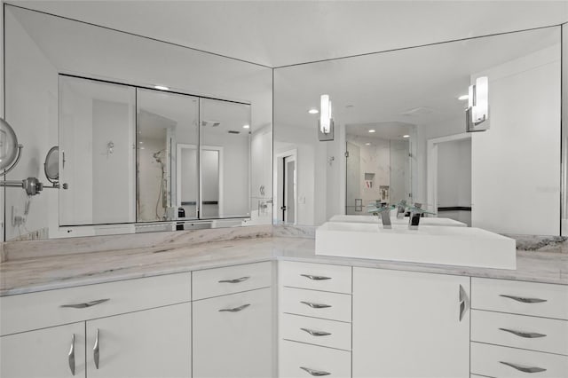 bathroom featuring vanity and a marble finish shower