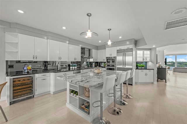 kitchen featuring wine cooler, a center island, open shelves, visible vents, and white cabinets