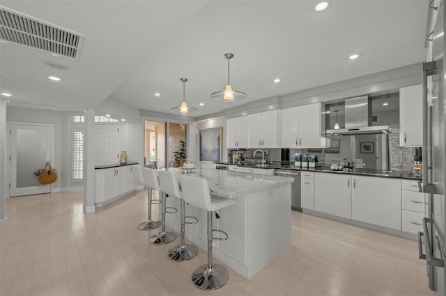 kitchen with visible vents, white cabinetry, a center island, dishwasher, and decorative light fixtures