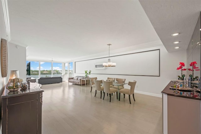 dining room with ornamental molding, a textured ceiling, a chandelier, light wood-type flooring, and baseboards