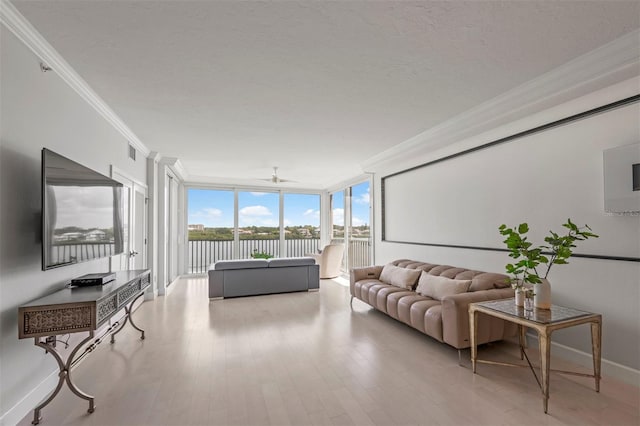 living area featuring a textured ceiling, visible vents, expansive windows, light wood finished floors, and crown molding