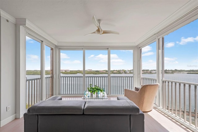 sunroom / solarium featuring a water view, plenty of natural light, and ceiling fan