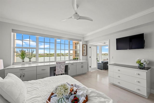 bedroom with light wood-style floors, crown molding, and built in desk