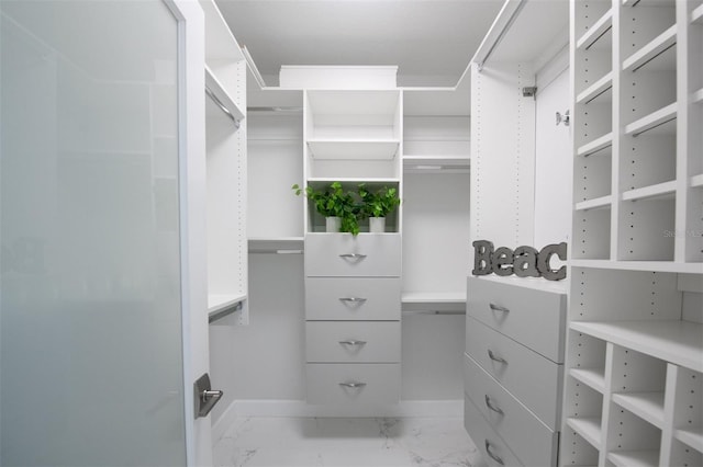 spacious closet featuring marble finish floor