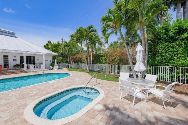 pool featuring outdoor dining space, a patio area, and fence