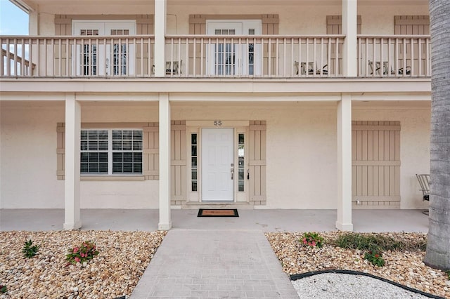 doorway to property featuring a balcony and stucco siding