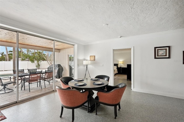 dining room with ornamental molding, a textured ceiling, baseboards, and speckled floor