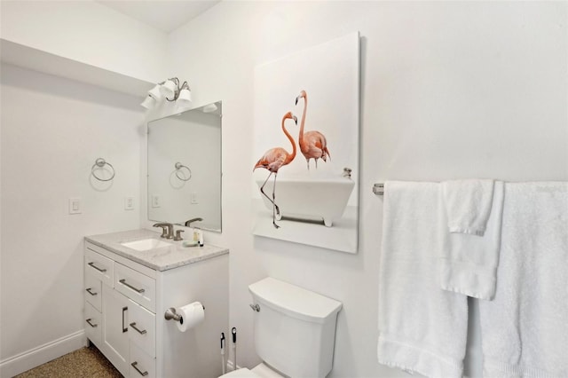 bathroom with toilet, baseboards, and vanity