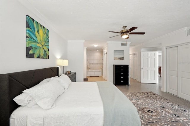 bedroom featuring visible vents, ornamental molding, multiple closets, and ensuite bathroom