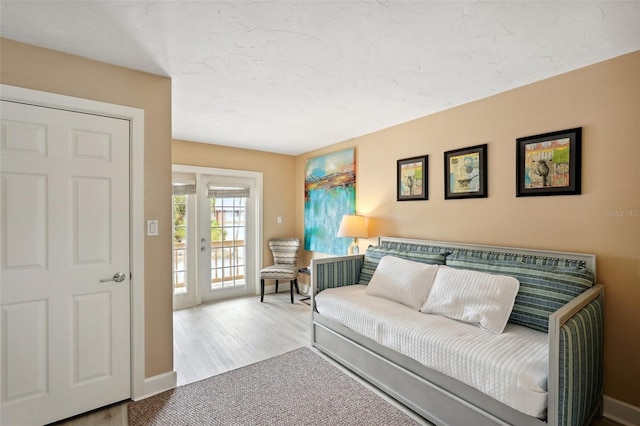 living room with light wood finished floors, baseboards, and a textured ceiling