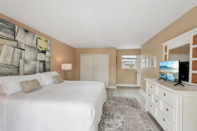 bedroom featuring baseboards, a closet, and light wood-style floors