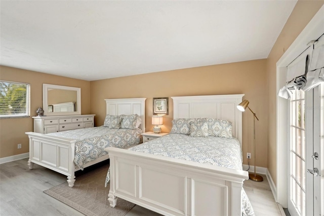 bedroom featuring light wood finished floors and baseboards