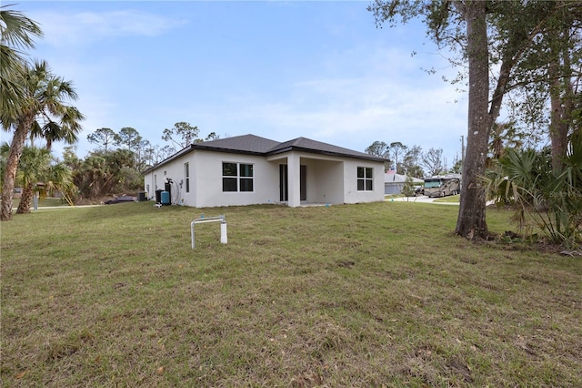 back of house featuring a lawn and stucco siding