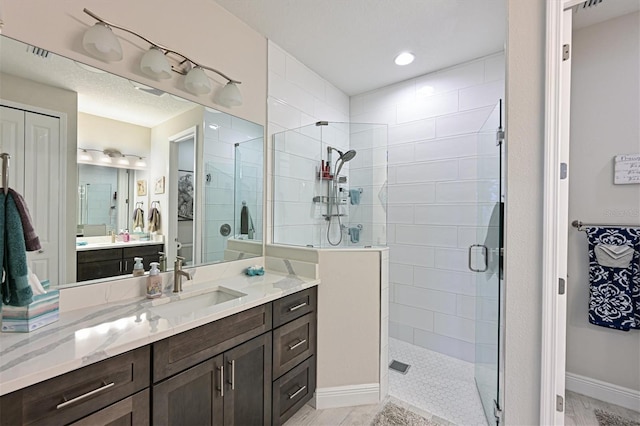 full bath with a shower stall, baseboards, a closet, and vanity