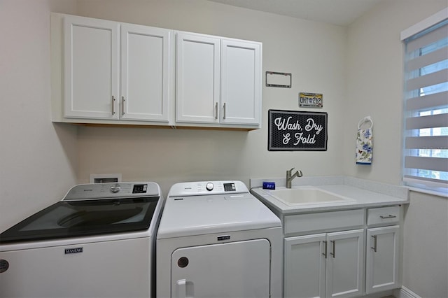 laundry area featuring a sink, washing machine and dryer, and cabinet space