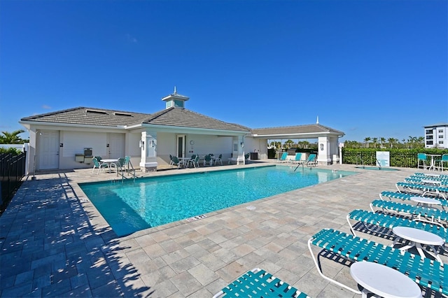 pool with a patio and fence