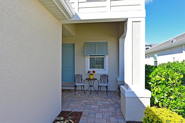 property entrance featuring a patio and stucco siding