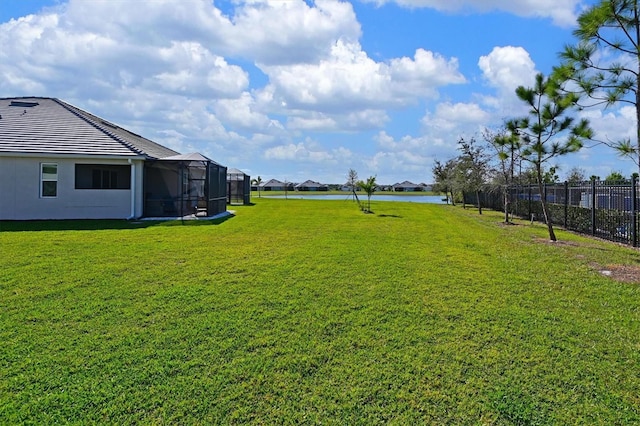 view of yard featuring a lanai and fence