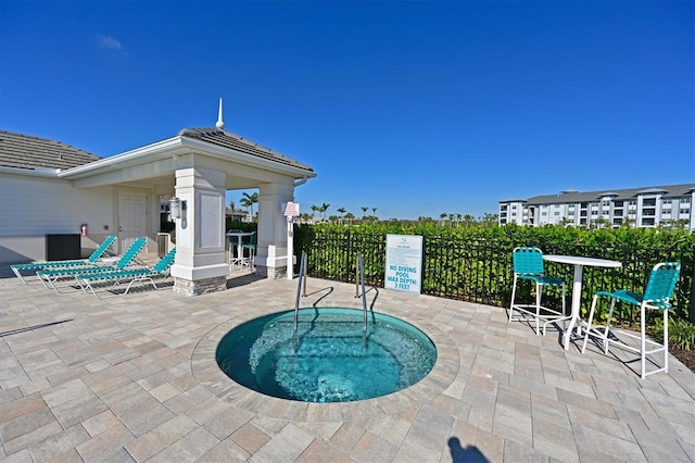 view of pool featuring a patio, a gazebo, fence, and a hot tub