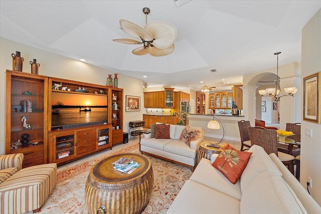 living area featuring arched walkways, decorative columns, recessed lighting, visible vents, and ceiling fan with notable chandelier