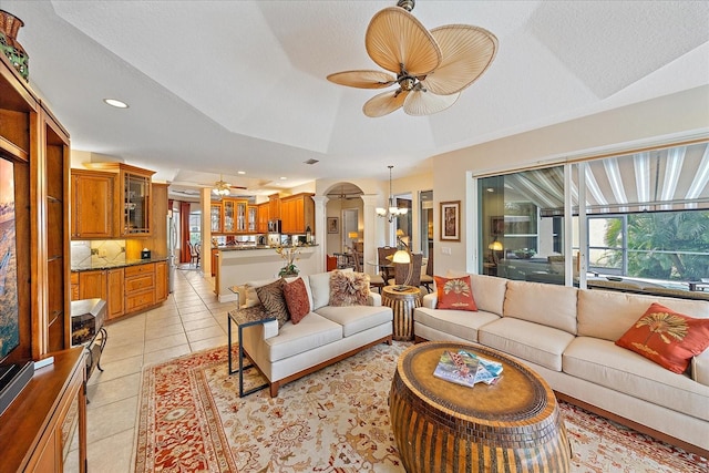 living room featuring light tile patterned floors, a textured ceiling, ceiling fan with notable chandelier, and recessed lighting