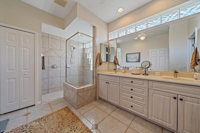 full bathroom featuring double vanity, a closet, visible vents, walk in shower, and a sink