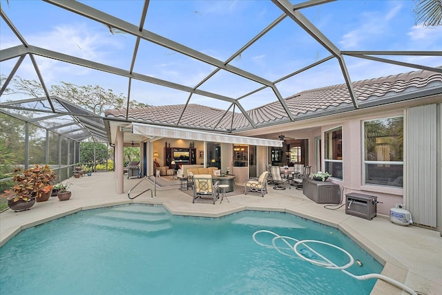 outdoor pool with glass enclosure, outdoor lounge area, and a patio