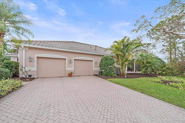 view of front of house featuring a garage, decorative driveway, a tile roof, and stucco siding