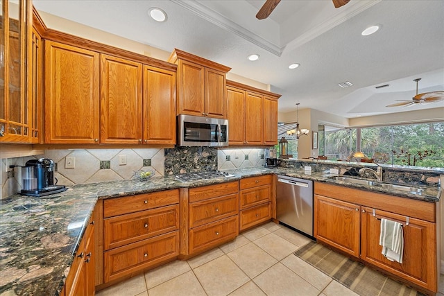 6617 Nautical Dr, Lakewood Ranch, FL 34202 - kitchen with a tray ceiling, appliances with stainless steel finishes, brown cabinetry, and a sink