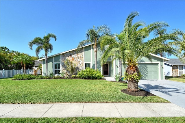 mid-century home featuring fence, a garage, stucco siding, a front yard, and concrete driveway