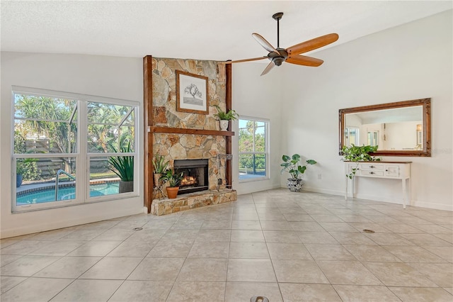 unfurnished living room with tile patterned floors, baseboards, a fireplace, and a ceiling fan