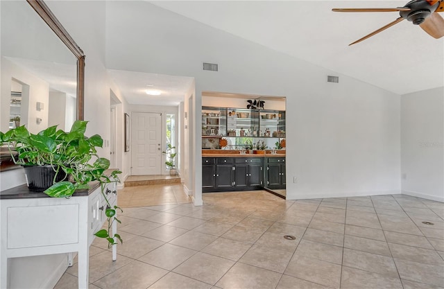 foyer entrance with light tile patterned flooring, ceiling fan, visible vents, and lofted ceiling