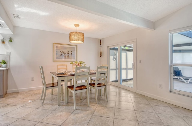dining space featuring baseboards, light tile patterned flooring, and a textured ceiling