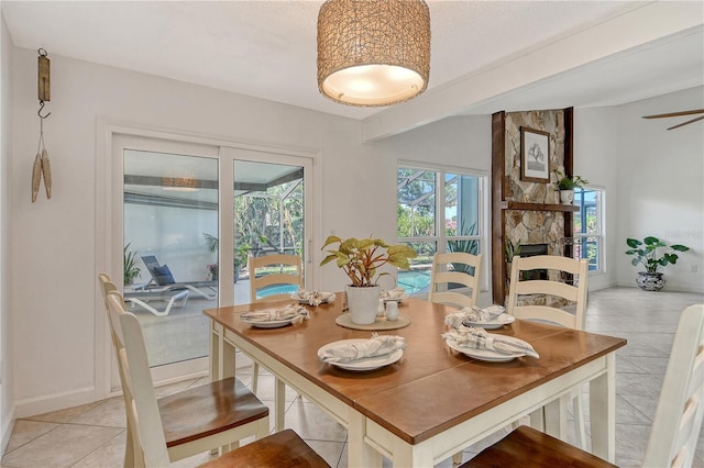 dining space featuring light tile patterned floors and a fireplace