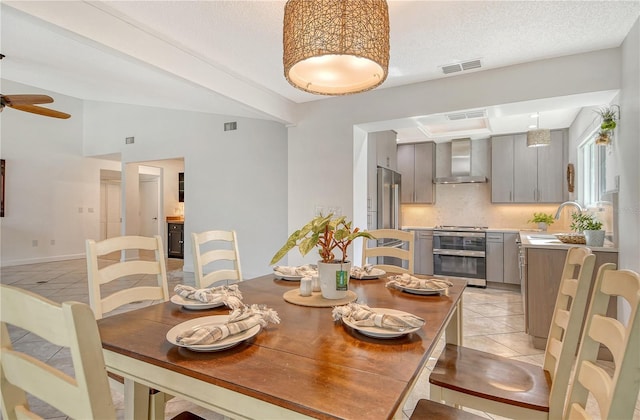 dining space with visible vents, ceiling fan, light tile patterned floors, and lofted ceiling