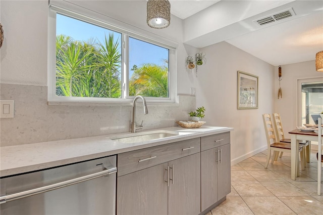 kitchen with visible vents, dishwasher, light tile patterned floors, a sink, and backsplash