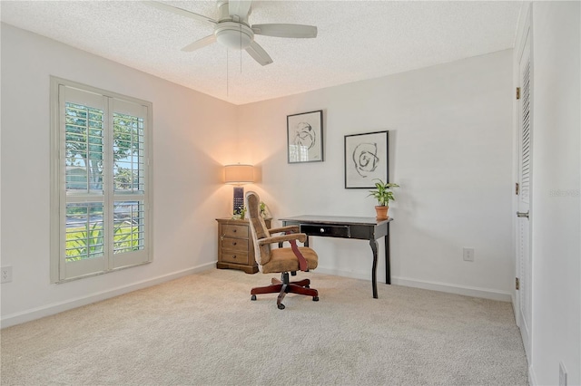 office area featuring baseboards, a ceiling fan, carpet, and a textured ceiling
