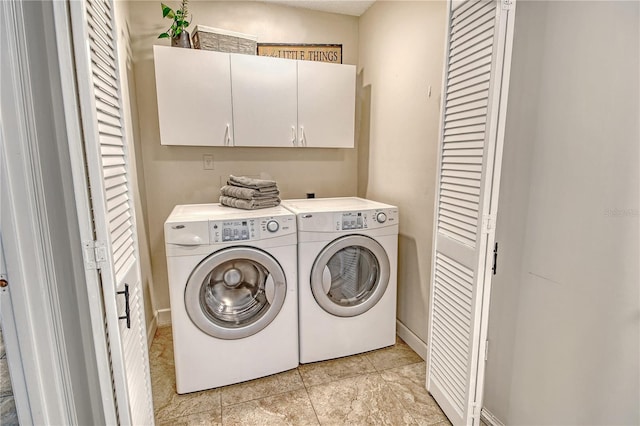 washroom featuring light tile patterned floors, separate washer and dryer, and cabinet space