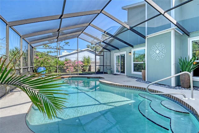 outdoor pool featuring a patio and glass enclosure