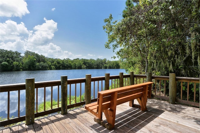 wooden deck with a water view and a view of trees