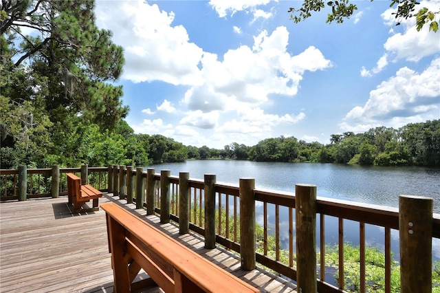 view of dock with a water view and a wooded view
