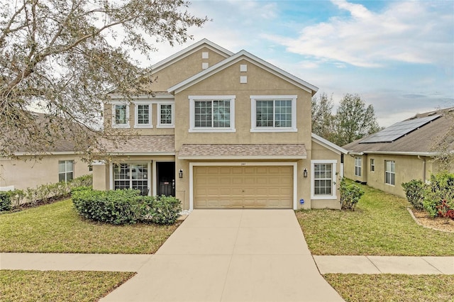 traditional home featuring a garage, a shingled roof, concrete driveway, stucco siding, and a front lawn