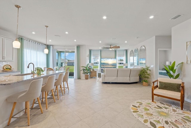 living room featuring light tile patterned floors, visible vents, a ceiling fan, and recessed lighting