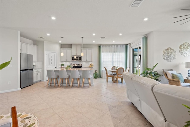 living area with recessed lighting, visible vents, baseboards, and light tile patterned floors