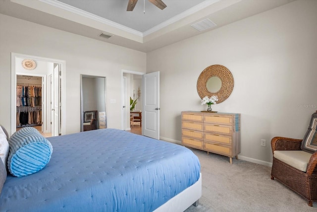 bedroom featuring visible vents, ornamental molding, a tray ceiling, and light colored carpet