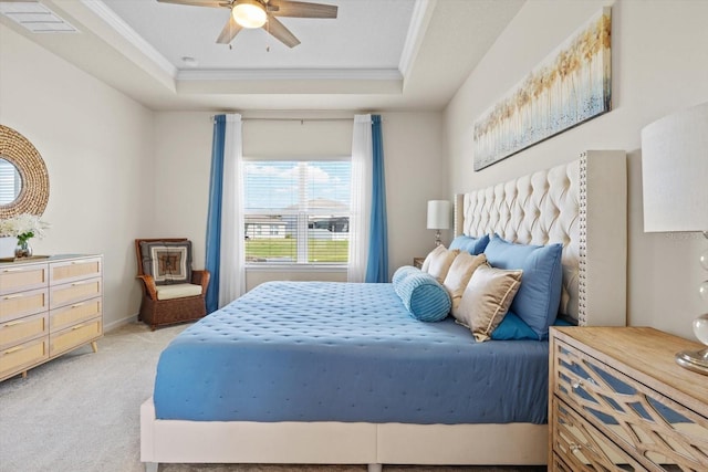 bedroom with light colored carpet, visible vents, a raised ceiling, and ornamental molding