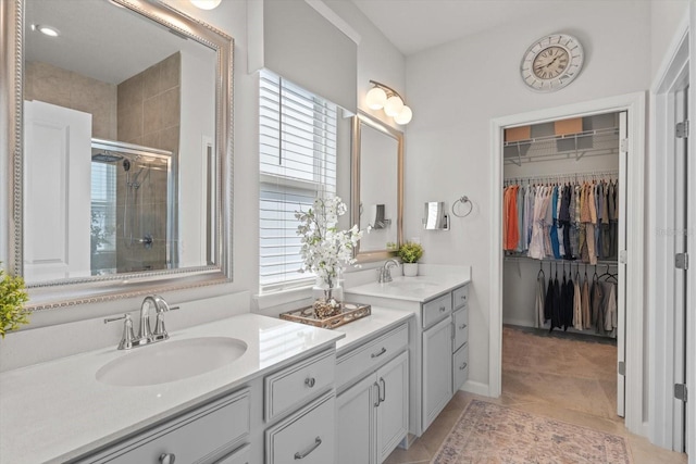 bathroom featuring a wealth of natural light, a shower stall, vanity, and a spacious closet