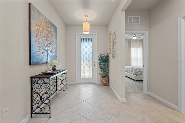 tiled foyer entrance with visible vents and baseboards