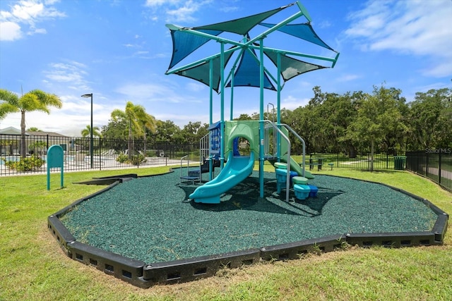 community play area with fence and a yard