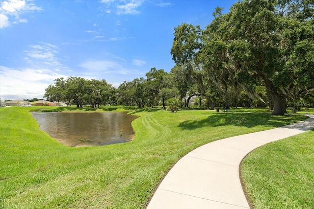 view of home's community with a lawn and a water view